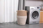 Jute and white laundry hamper next to a washing machine in a laundry room