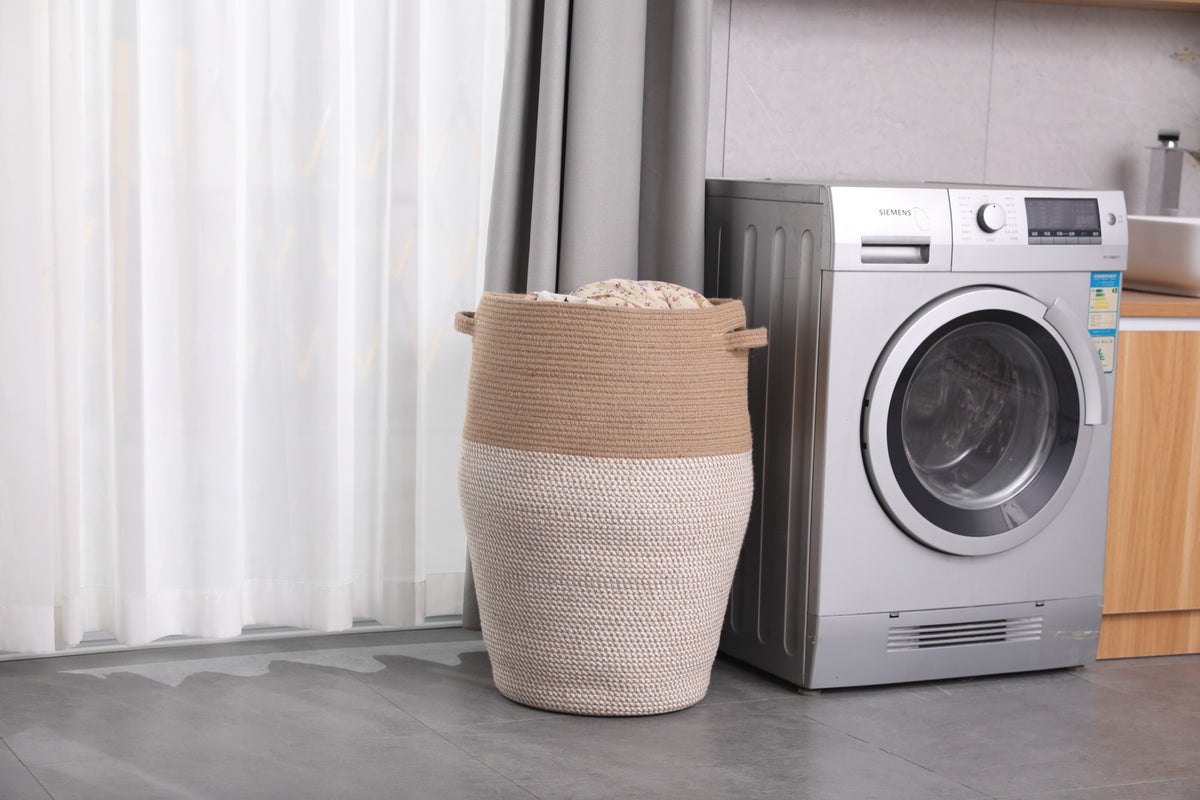 Jute and white laundry hamper next to a washing machine in a laundry room