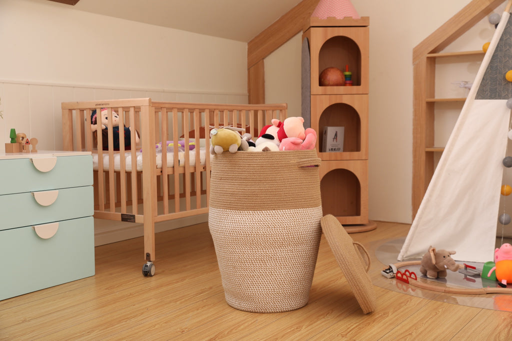 Jute and white tall storage basket in a nursery next to a crib